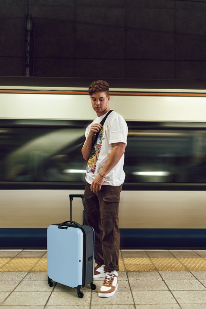 Man with 55 cm Easypack collapsible suitcase, tidy storage at home