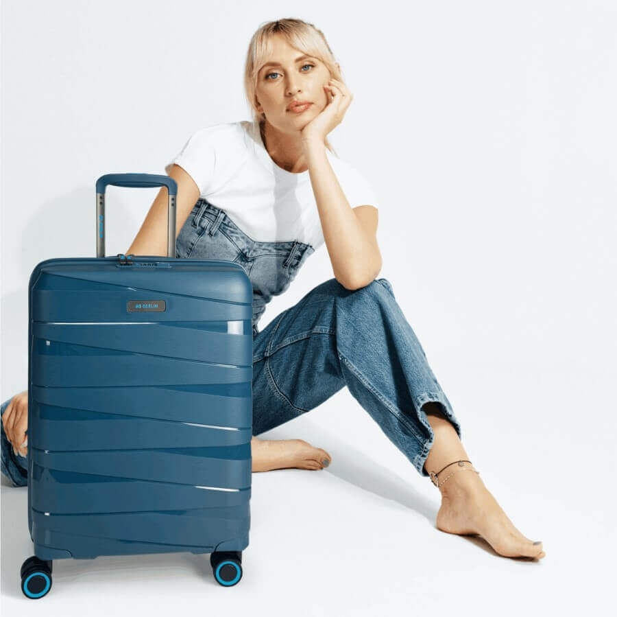 Woman sitting with 56 cm TED hard-shell suitcase, bargain hunter’s pick